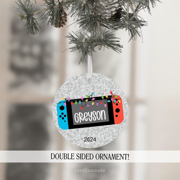This fun christmas ornament features a video game with christmas lights and is personalized with your name.