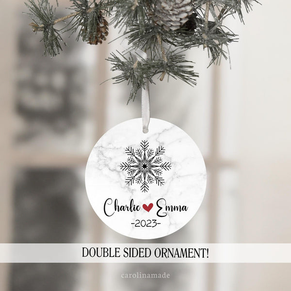 This Christmas ornament has a large snowflake at the top. It is personalized at the bottom with couples name and a year.
