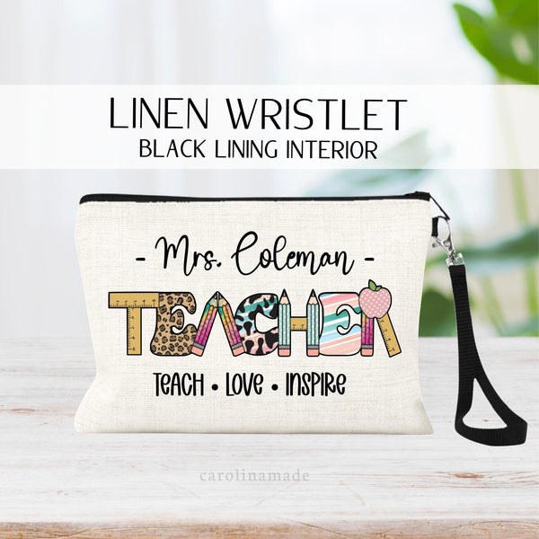 Personalized linen zipper pouch that has teachers name at the top, TEACHER in the middle in a fun font with ruler, pencils, apples, stripes and leopard print. And the text at the bottom says Teach Love Inspire in black font.