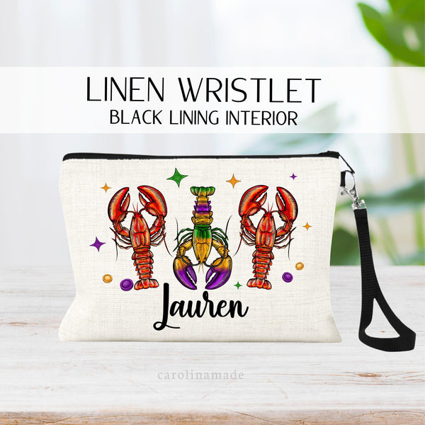this linen zipper pouch features three crayfish colored for mardi gras. personalize the bottom with your name.
