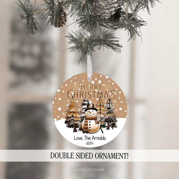 Merry Christmas gender neutral snowman ornament. With tan snowy background, beige trees and the bottom is personalized with name and year.