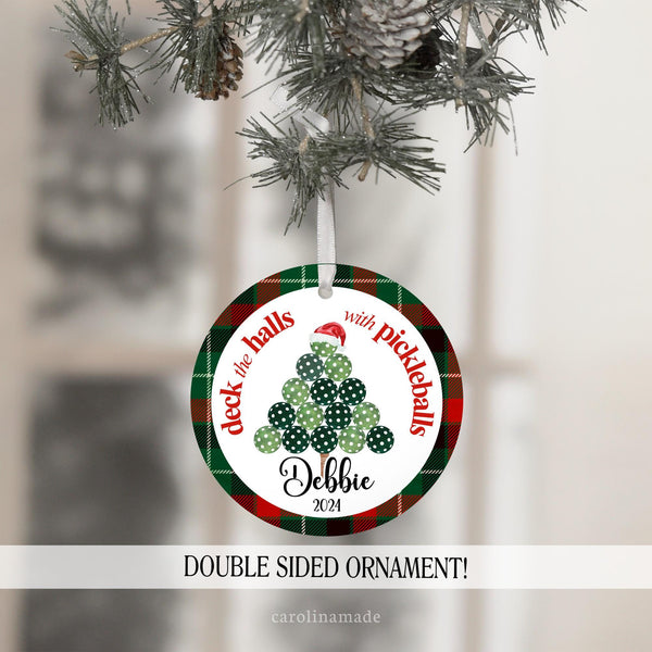 This Christmas ornament features a red & green plaid background with plaid pickleball christmas tree in the center and says deck the halls with pickleballs around it. It is personalized at the bottom with your name and year.