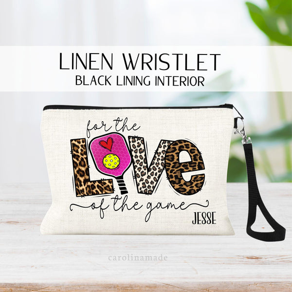 This linen zipper pouch features a pickleball design that says For the Love of the game. With a pickleball paddle in the place of the O in Love. It is personalized at the bottom with your name.