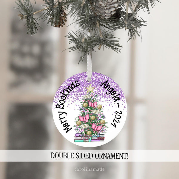 This ornament features a large christmas tree in the center filled with books, gold balls, and candy canes. It says Merry Bookmas and is personalized with your name and the year.