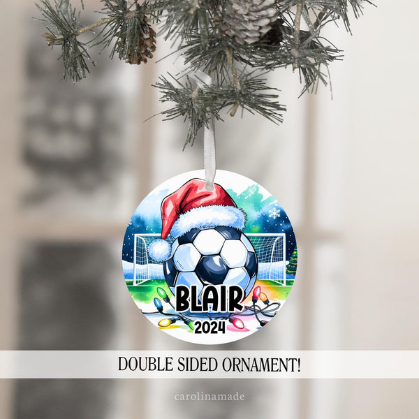 This Christmas ornament features a large soccer ball with a Santa hat in a soccer field with Christmas lights. It is personalized with your soccer players name and the year at the bottom.