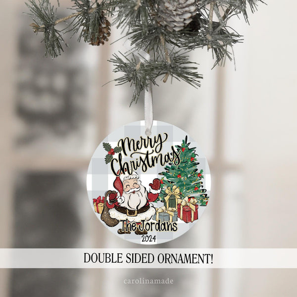 This ornament features a fun classic Christmas design with gray plaid background, Merry Christmas at the top. Santa with Christmas gifts and a Christmas Tree.  Your name is personalized at the bottom and the year.