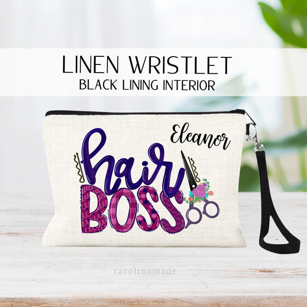 This linen zipper pouch feathres a fun text that says hair boss. It has scissors and flowers next to it. It is personalized on the top corner with your name