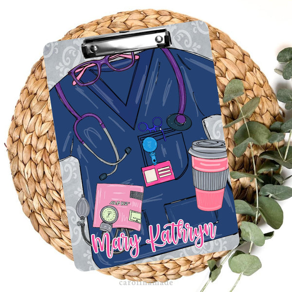 This personalized clipboard features a navy blue scrub design with stethoscope, coffee, blood pressure cuff and has a name at the bottom.