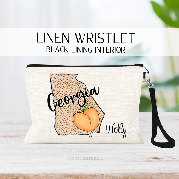 This zipper pouch features a large Georgia State with Georgia written across it and a large Georgia Peach in the corner of the sate. Wristlet is personalized at the bottom with your name.