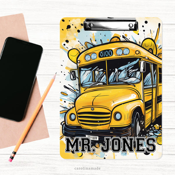 This double sided clipboard features a large school bus covering most of the board.With a blue, yellow, white paint splash background. It is personalized at the bottom with a name