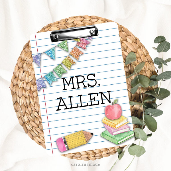 This fun clipboard features a paper like background with glitter banner, pencil and stack of books on it. The center is personalized with your teachers name.
