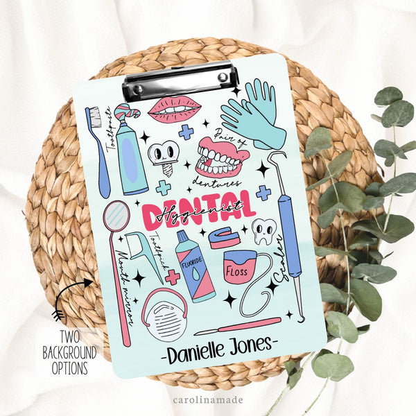 This double sided clipboard features a fun dental design with dentist elements like dentures, toothpaste, gloves, mask, floss, fluoride, etc. It says dental hygienist in the center. And is personalized at the bottom with a name.