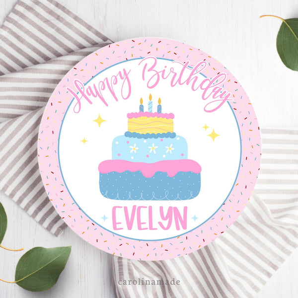 This fun kids birthday plate features a pink sprinkles background with a white center that says happy birthday and is personalized with the childs name. The center has a beautiful pink, blue and yellow birthday cake.