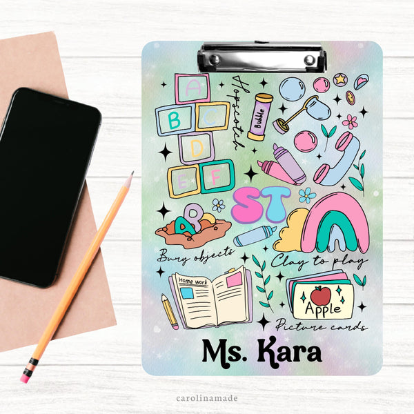 This double sided clipboard features a multi color pastel background with ST in the center and different speech therapy clip art surrounding it. Blocks, Bubbles, Clay, Book,picture cards, etc. It is personalized at the bottom with a name.