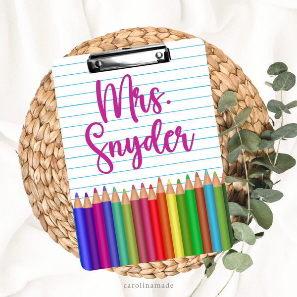 This double sided clipboard features a printed lined paper design with a row of color pencils at the bottom. It is personalized at your favorite art teachers name.