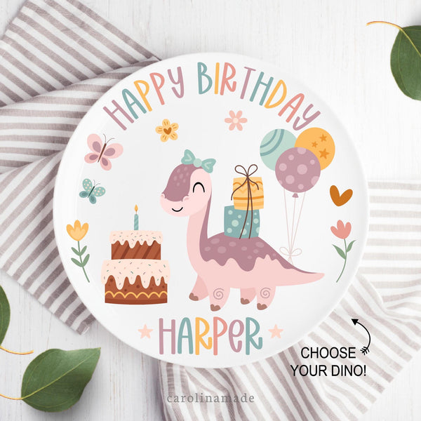This white Happy Birthday plate features a fun colorful design with dinosaur, presents, cake, balloons and flowers. The top says happy birthday and the bottom is personalized with childs name.