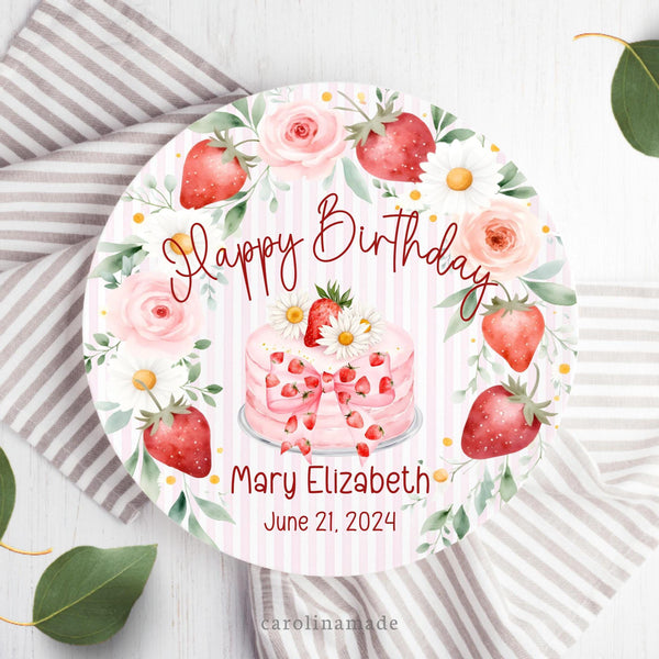 This white 10 inch plate features a pink stripped background with a floral and strawberry wreath. The center has a pink cake with strawberries and a bow. It says Happy Birthday and is personalized with name a date of birth.