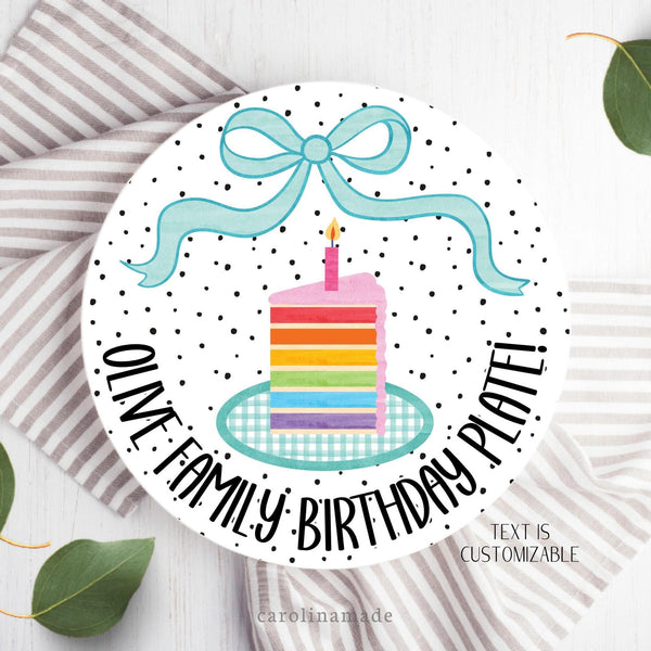 This 10 inch plate features a white and black polka dot theme with a teal bow at the top and rainbow cake in the center. The bottom is personalized with your custom saying and family name.