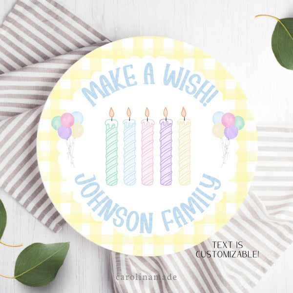 This plate features a pastel yellow gingham background with pastel candles in the center in various colors. There are also matching balloons on both sides of the candles. The top text says make a wish and bottom is personalized with your family name.