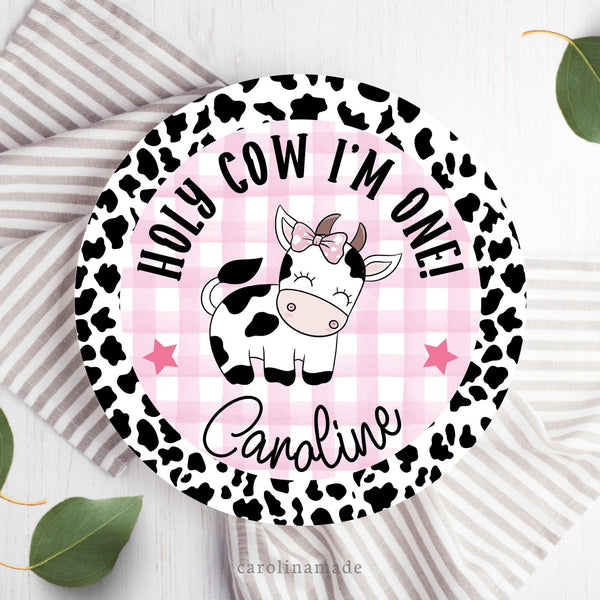 This Holy Cow I'm One theme birthday plate features a cow print edge with pink gingham in the center. There is a cow with a bow in the center also. The bottom is personalized with your childs name.