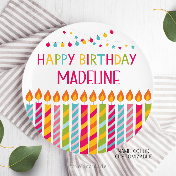 This bright colorful happy birthday plate features a row of colorful candles across the bottom. The top has string lights. And the Center says Happy Birthday with your childs personalized name.