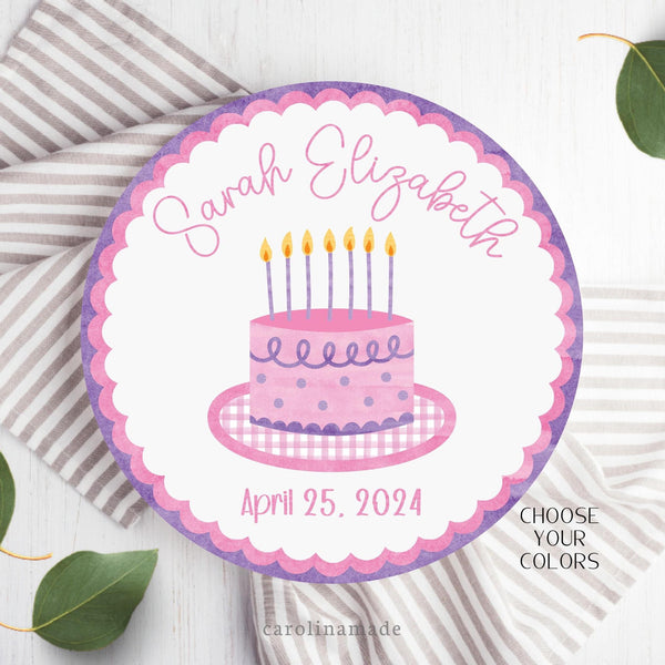 This cake plate features a watercolor rim and watercolor scallops. The center is white and has a matching color coordinated cake in the center.  The top is personalized with your childs name. And the bottom has their date of birth.