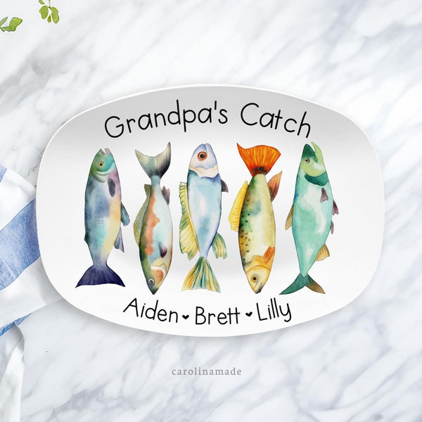 This white 10x14 serving platter features a row of colorful fish in the center. The top is personalized with a name and the bottom has kids or grandchildrens names.