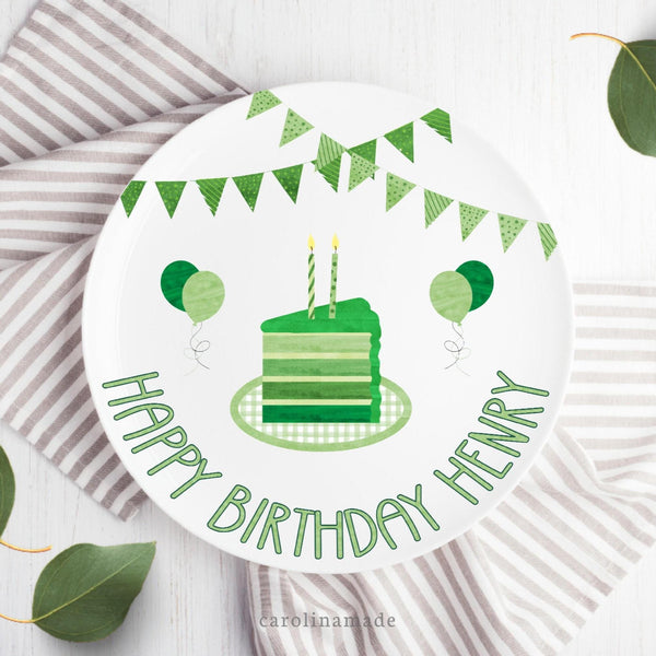 This 10 inch plate features white background and green theme birthday design. A green party banner at the top with a multi layer cake in the center in different shades of green . The bottom says Happy birthday and is personalized with your childs name. The plate also features balloons in shades of green.