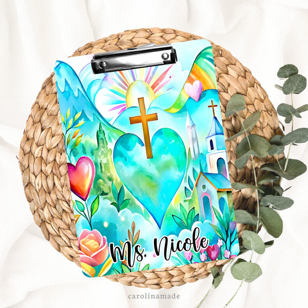 This beautiful double sided clipboard features a bright beautiful colors.  There is a big heart in the center with a cross. It shows an outdoor theme with sun, mountains, church, flowers and more. Many different vibrant colors shown. The bottom is personalized with a name.