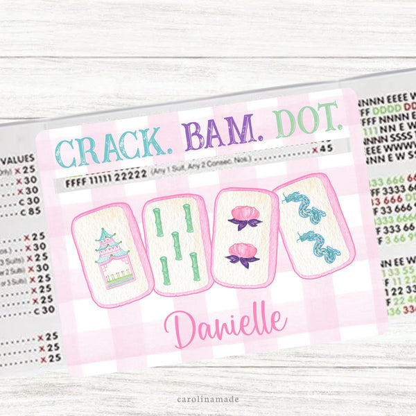 This acrylic mahjong line reader features a gingham background in your choice of pink or purple with four tiles in the center. The top says crack bam dot and the bottom is personalization with your name. Matching zipper pouch available also.