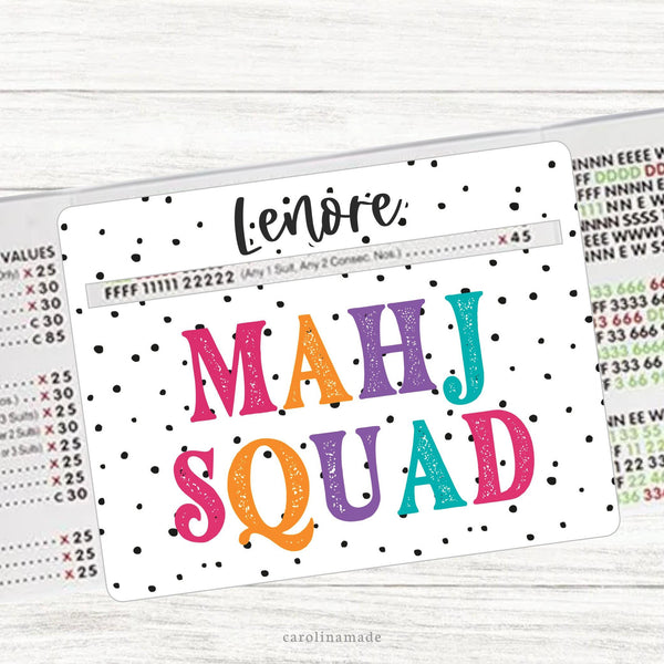 This acrylic mahjong line reader features a white background with black dots and colorful text that says Mahj Squad. The top is personalization with your name. Matching zipper pouch available also.