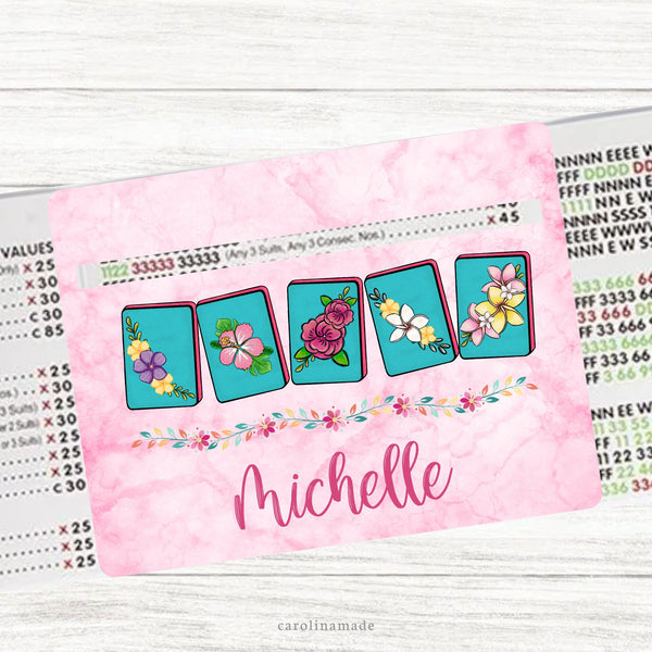 This acrylic mahjong line reader features a pink background with 5 floral colorful mahjong tiles and your name personalized at the bottom. Matching zipper pouch available also.