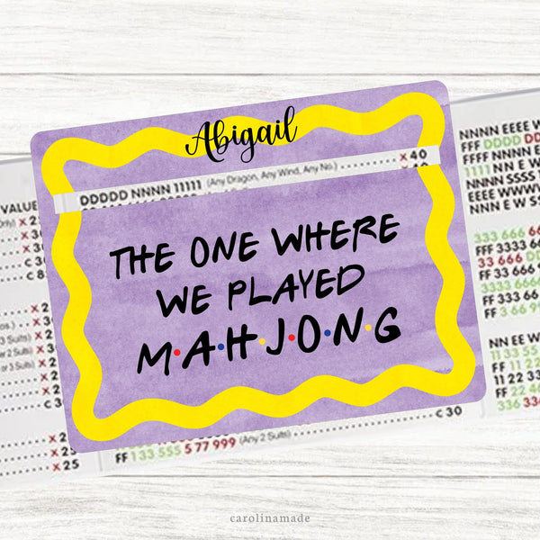 This acrylic mahjong line reader features a FRIENDS TV Show theme with a purple background and yellow wavy frame. It says The one where we play Mahjong in Friends theme font. And is personalized at the top with your name.