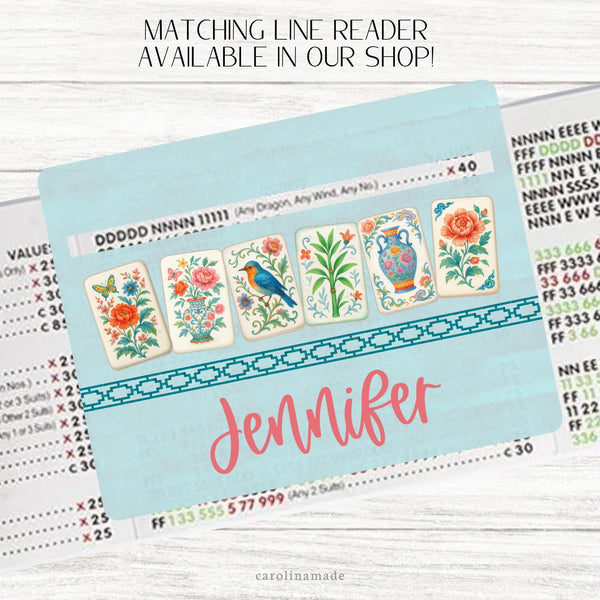 This acrylic mahjong line reader features a teal background with 6 floral colorful mahjong tiles and your name personalized at the bottom. Matching zipper pouch available also.