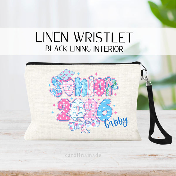 This linen zipper pouch features a pink and blue grand millennial color design that says senior 2026 with a graduation hat and paper. It is personalized in the corner with your name.