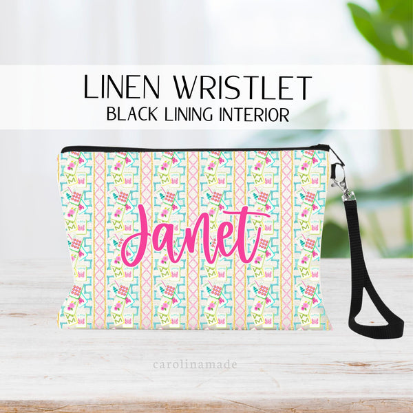 This Mahjong themed linen zipper pouch features rows of colorful bamboo in gold, pink and turquoise with several mahjong tiles on it. The Center is personalized with your name.