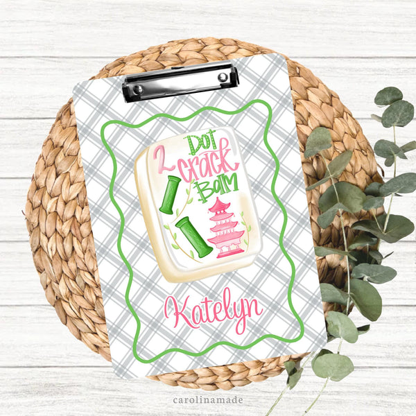 This colorful double sided clipboard features a grey and white stripped background with green wavy border. The center features a mahjong tile that says dot crack bam and is personalized on the bottom with your name.
