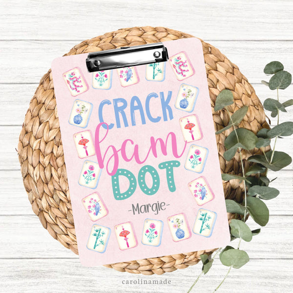 This colorful double sided clipboard features a pink background with a mahjong tile border. The center features says crack bam dot and is personalized on the bottom with your name.