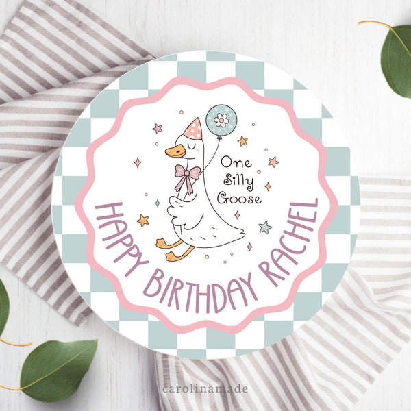 This fun colorful plate features a checker background on the outer ring. Then a wavy circle in the center. With a Silly Goose holding a balloon and the personalized text at the bottom that says Happy Birthday and your child's name.