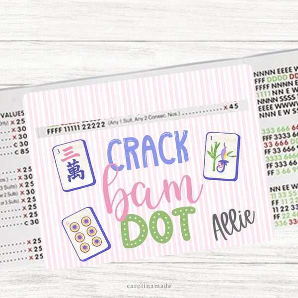 This acrylic mahjong line reader features a pink and white striped background with three tiles and text that says crack bam dot. The bottom corner is personalization with your name. Matching zipper pouch available also.