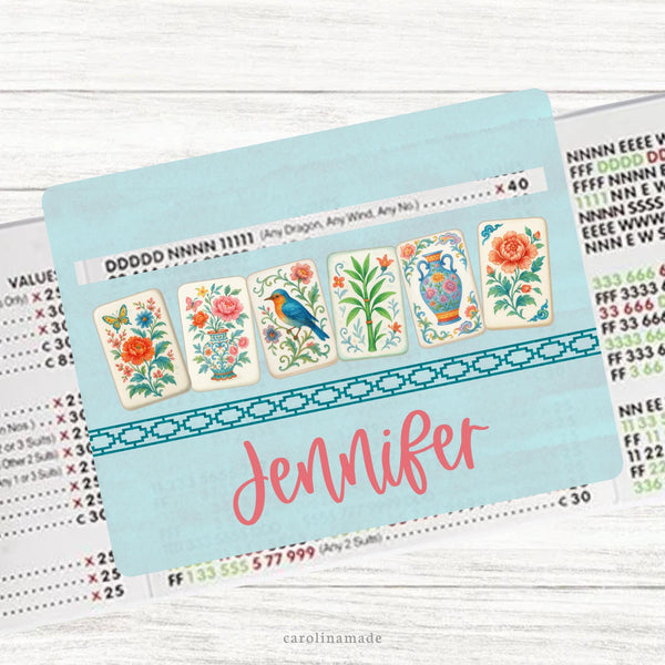 This acrylic mahjong line reader features a teal background with 6 floral colorful mahjong tiles and your name personalized at the bottom. Matching zipper pouch available also.