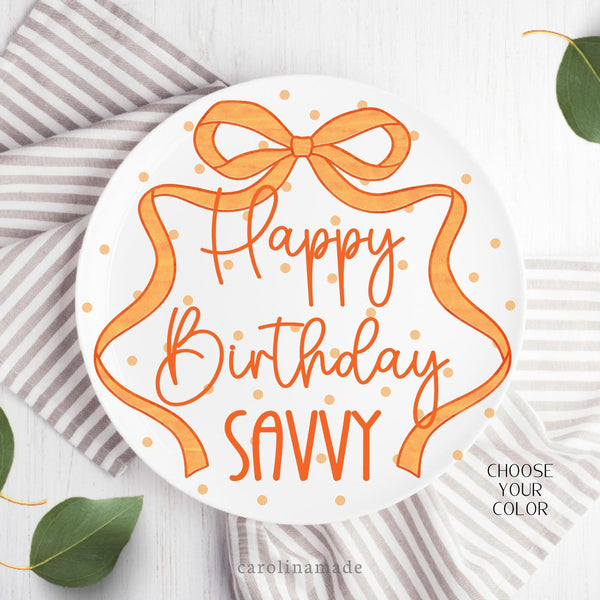 This ten inch plate features a orange poka dot plate with a long ribbon bow around the plate. It is personalized with your childs name.