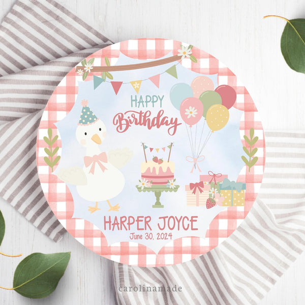 This fun colorful plate features a gingham background on the outer ring and a light blue sky look in the center. With a Goose, cake, presents, flowers, strawberries and balloons in the center. The text says Happy Birthday with your childs personalized name and date of birth at the bottom.