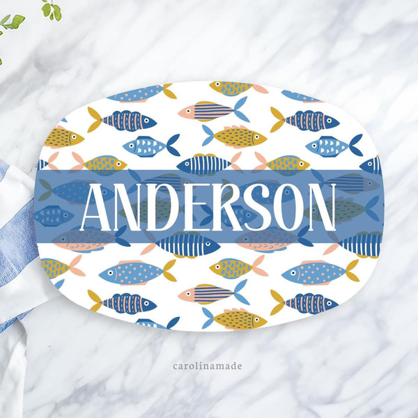 This large serving platter features a personalized last name in the center or customize the text to your needs. The plate has blue, coral and gold color sardines all over it.